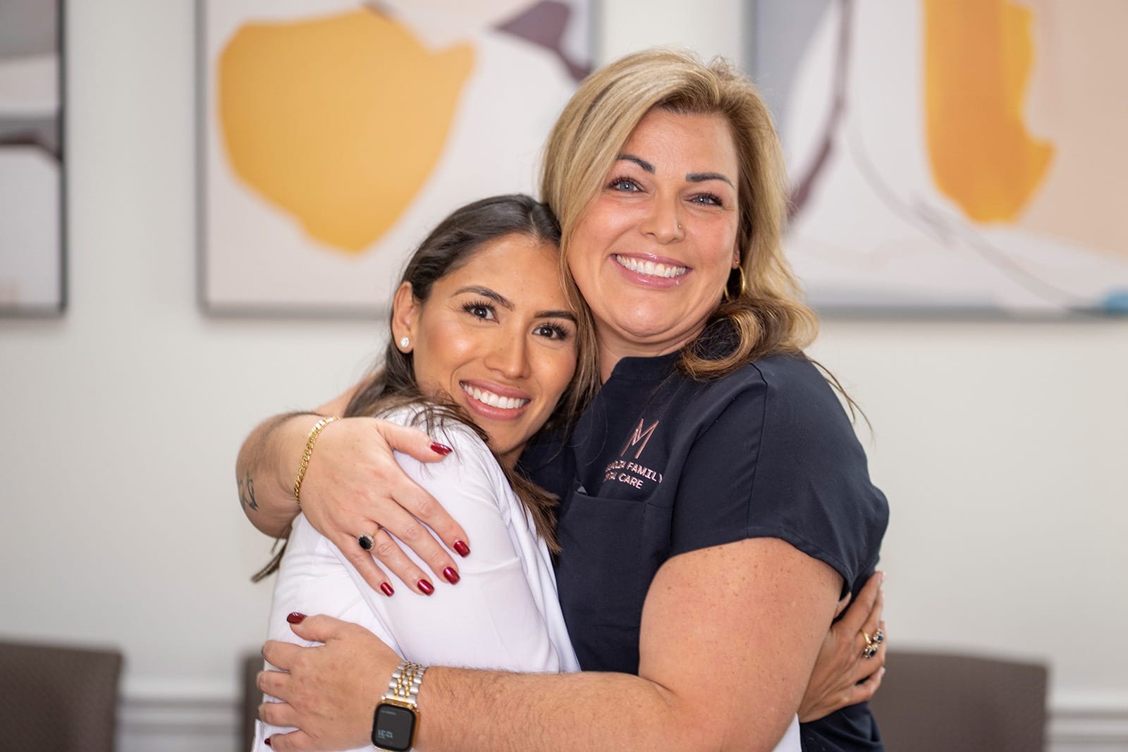 Dr. Rodriguez and her dental assistant giving each other a hug