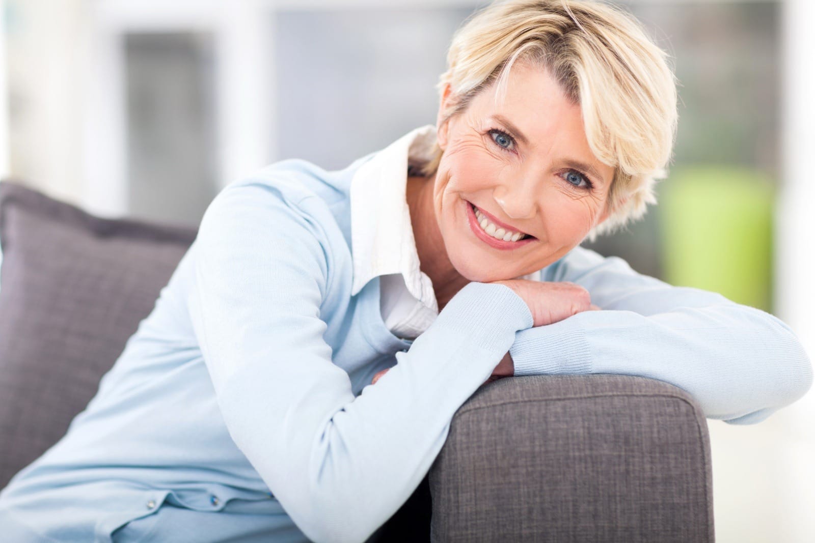 pretty senior woman relaxing on a couch at home