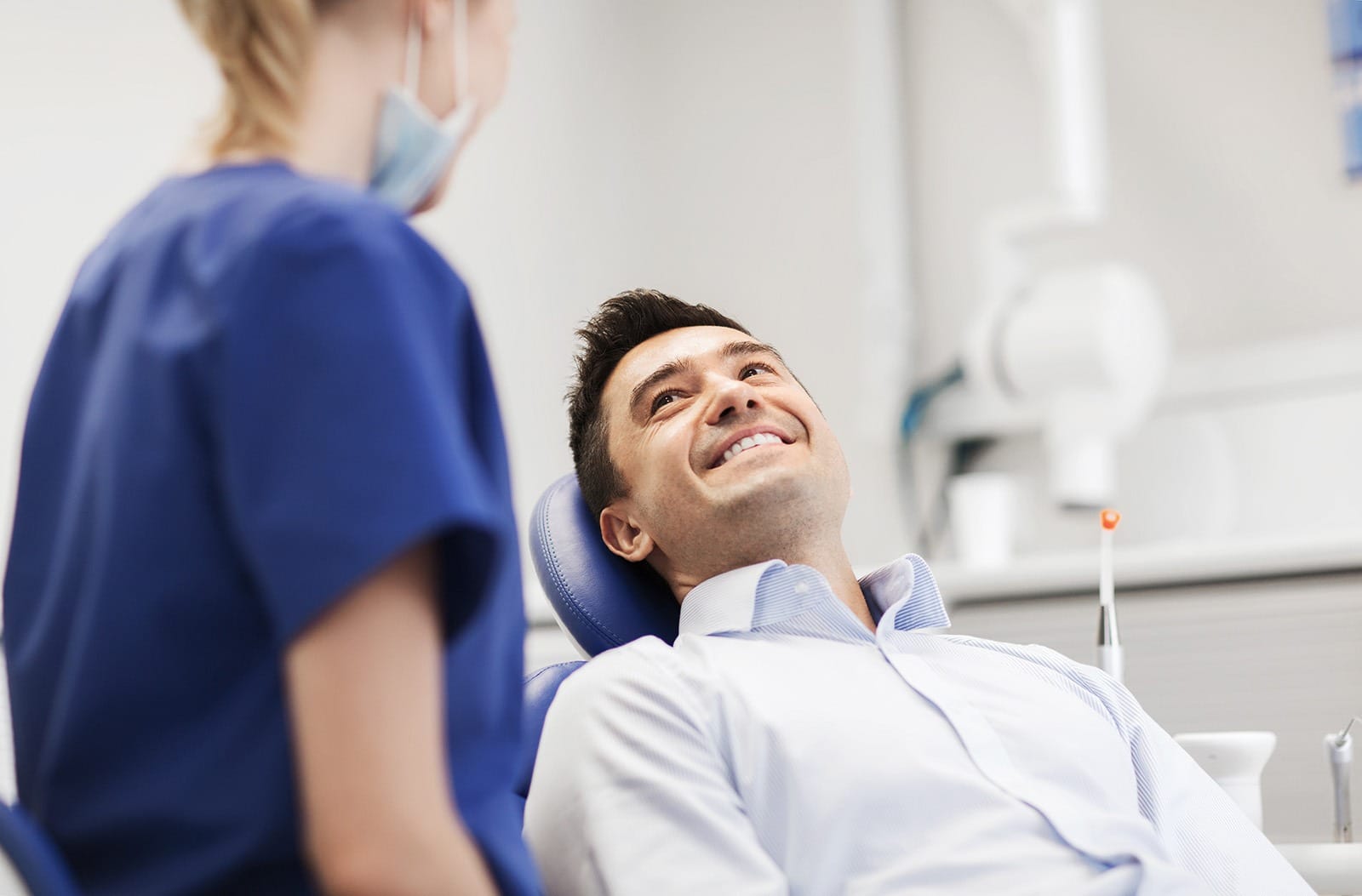 A female dentist checks in on a male patient before a procedure