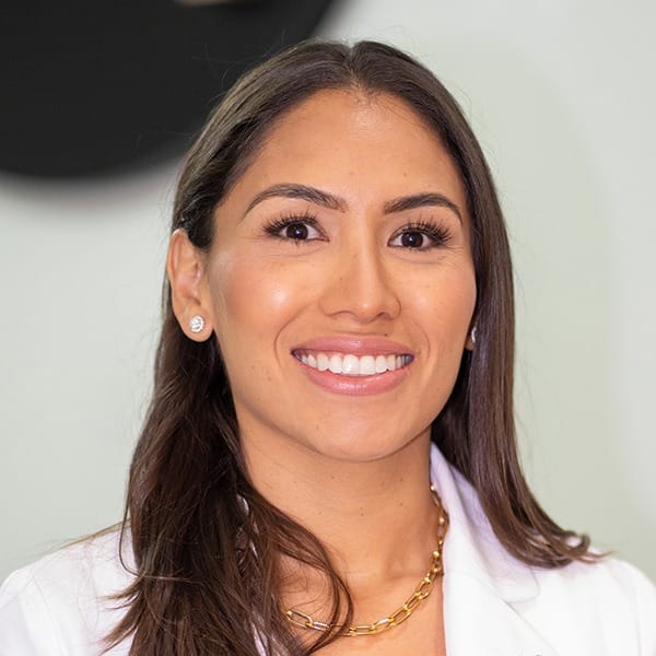 Portrait image of Dr. Paola Rodriguez smiling in a white coat.